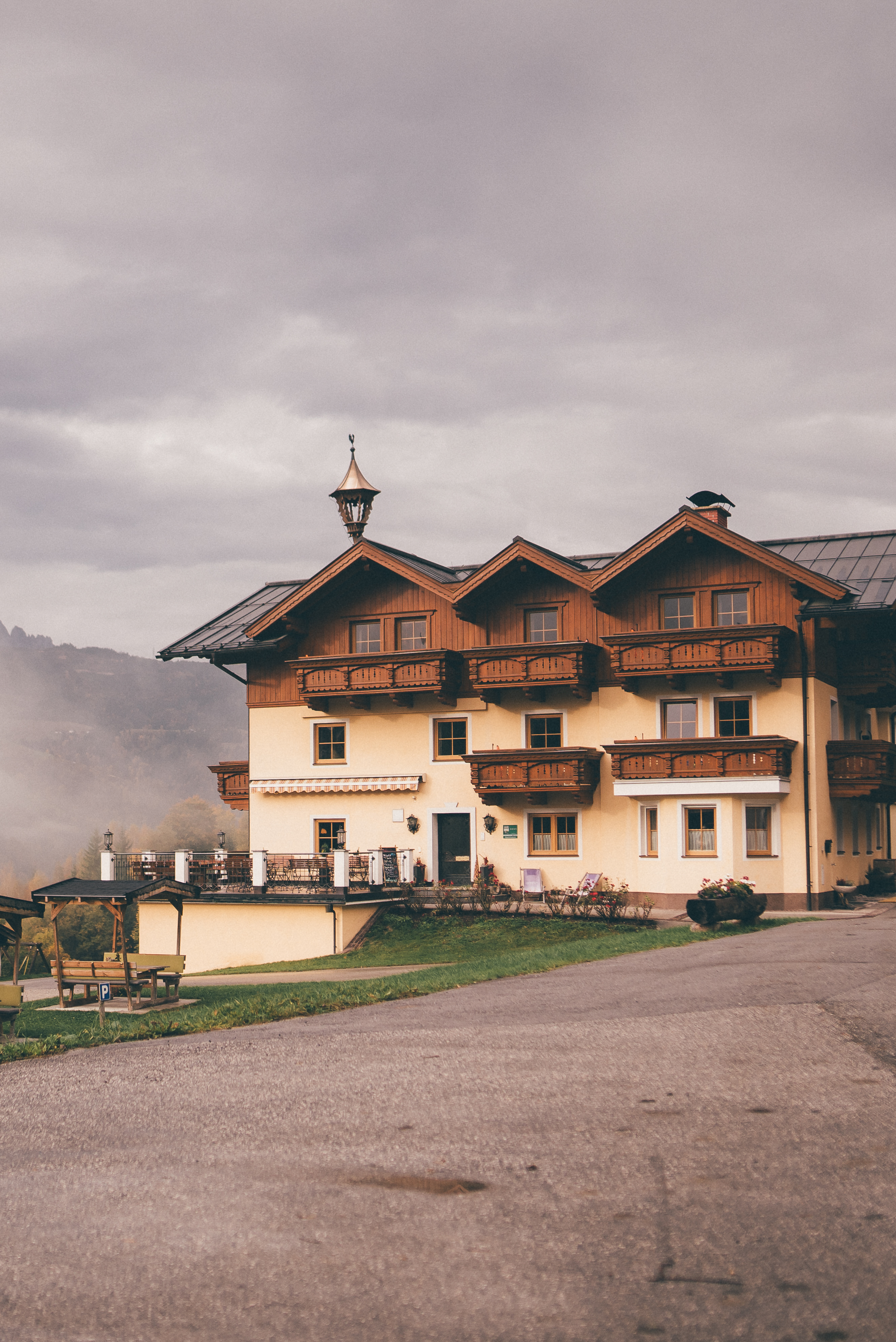 Gemütlicher Bauernhof mit Holz-Balkonen im Salzburger Land vor bewölktem Himmel